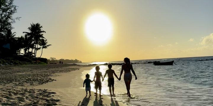 Family walk on the beach at sunset, Mauritius